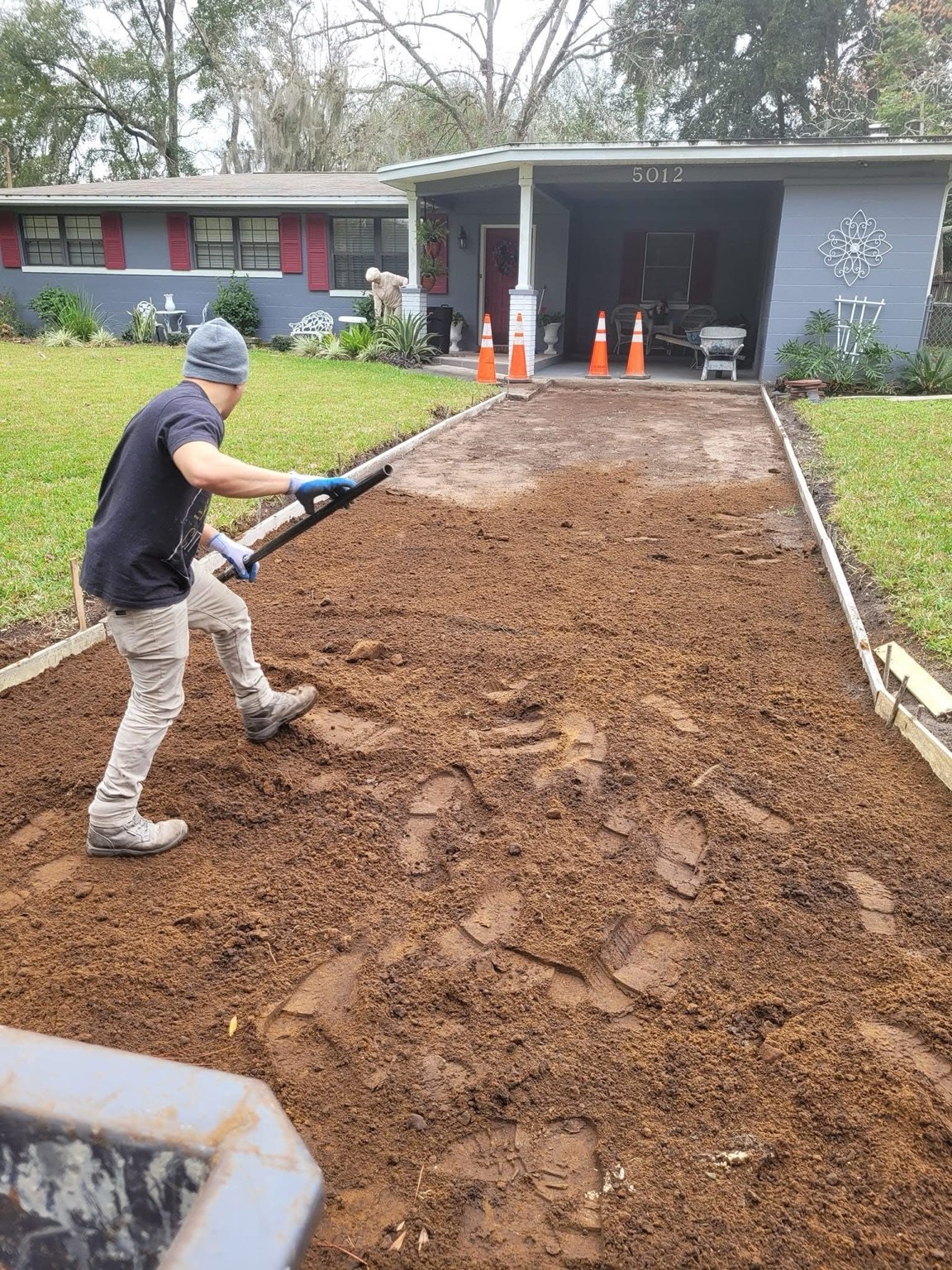 Worker preparing a residential driveway base